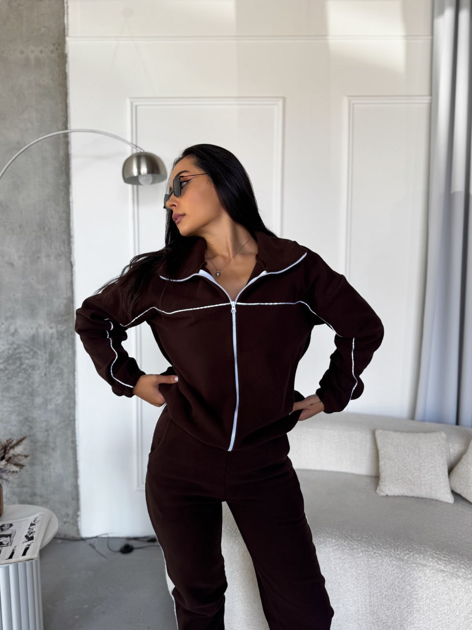 Person wearing a brown tracksuit in a modern room.