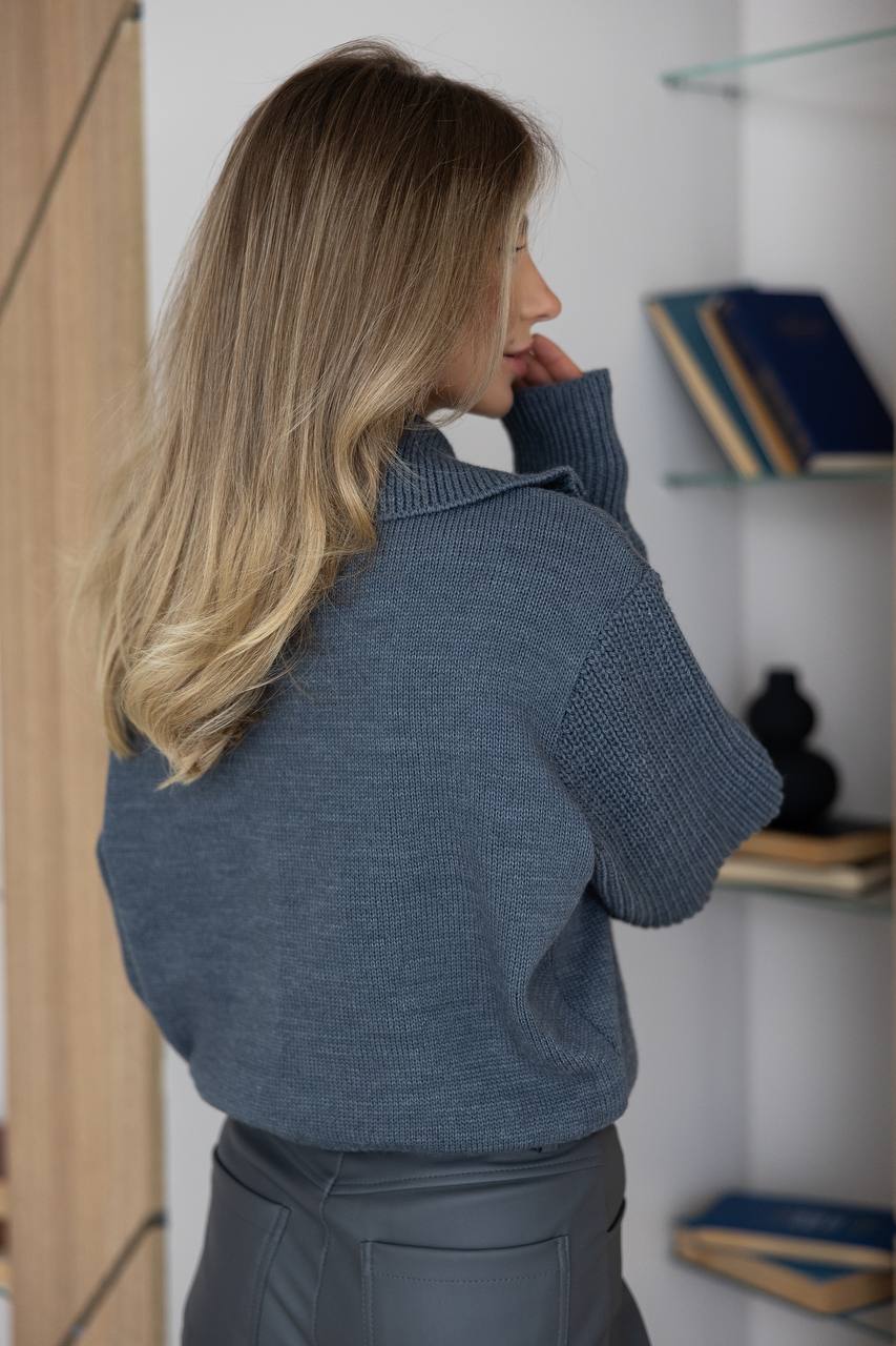 Woman wearing a blue sweater in an indoor setting