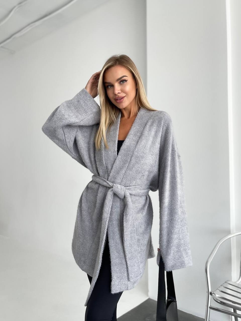 Woman wearing a gray robe against a white background