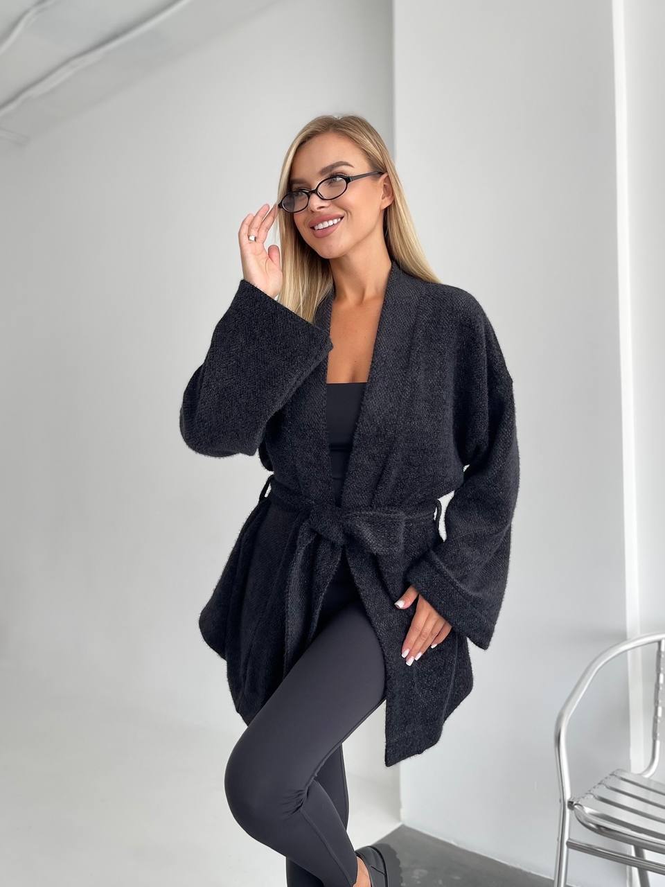 Woman wearing a dark gray robe against a white background