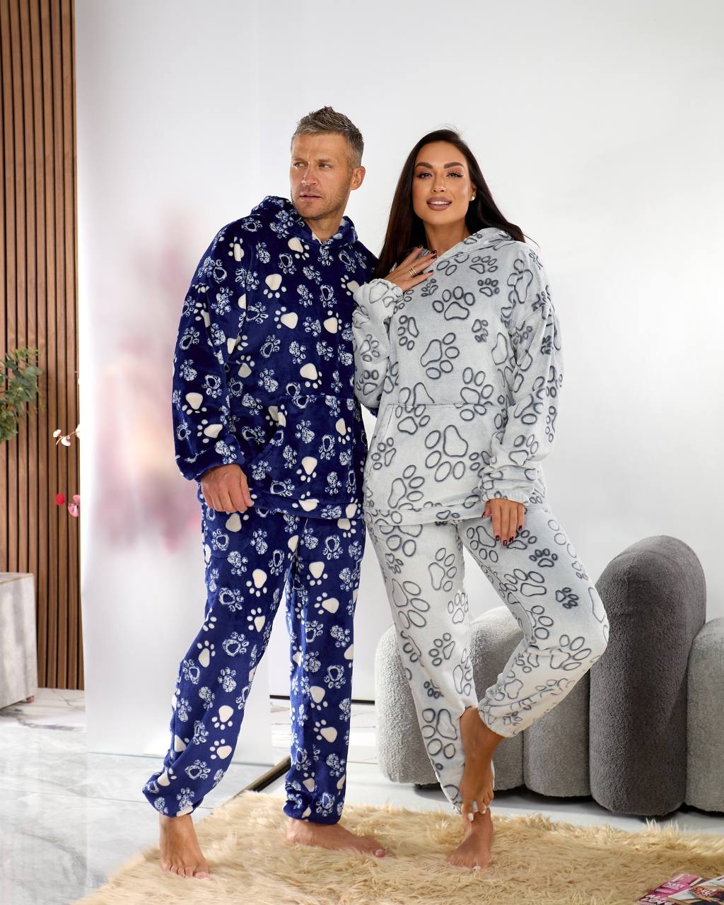 Two people wearing matching blue and white pajama sets with floral patterns in a living room.