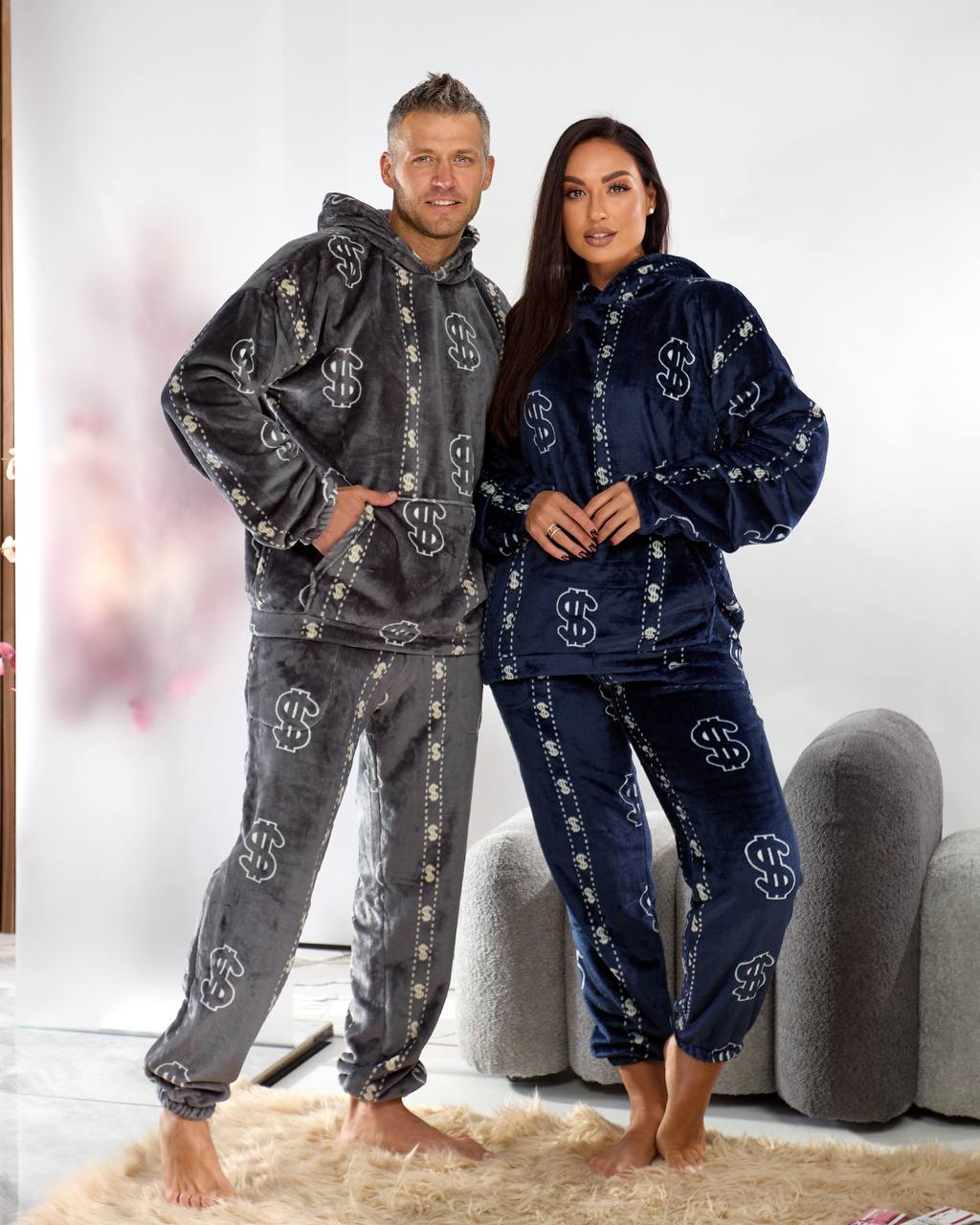 Two people wearing matching pajama sets in a living room.