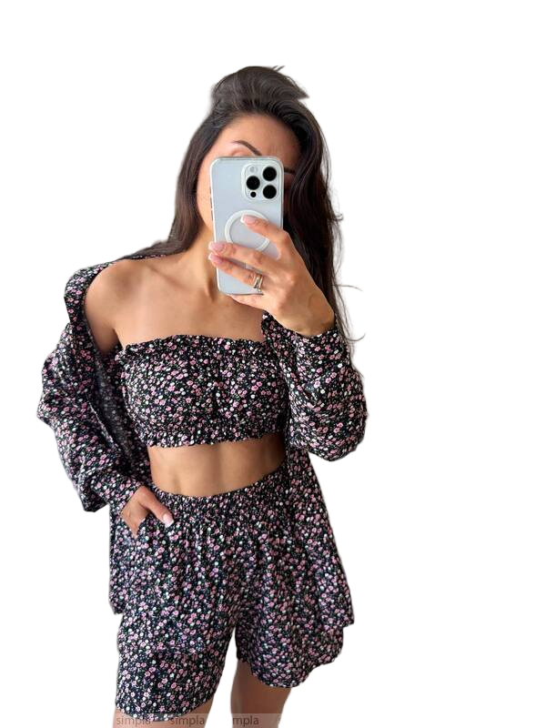 Woman taking a mirror selfie wearing a floral outfit on a white background