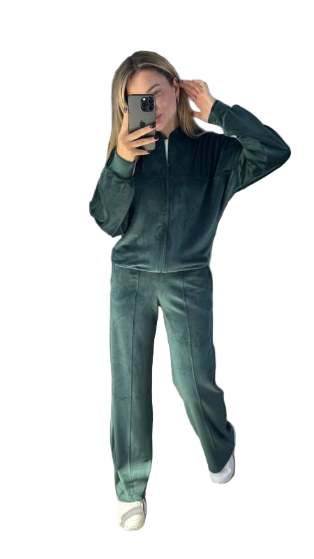 Person wearing a green tracksuit taking a mirror selfie on a white background