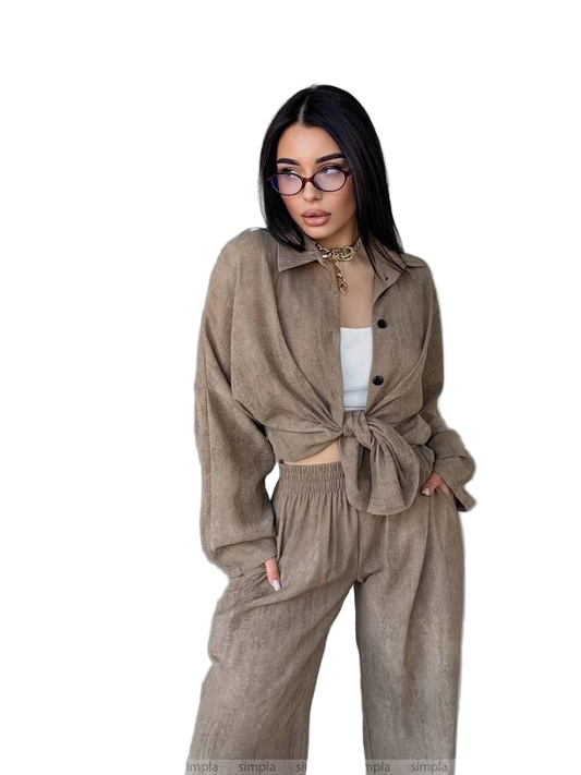 Woman wearing a beige outfit with a jacket and pants on a white background