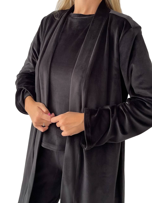 Person wearing a long black coat over a dark top on a white background