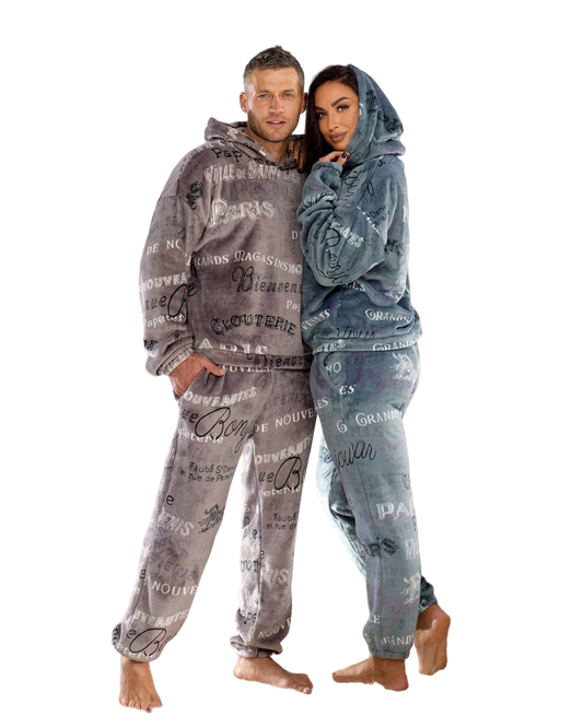 Two people wearing matching gray hoodies and pants with text design on a white background