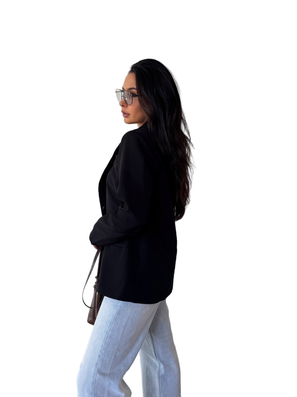 Woman wearing a black jacket and light blue jeans on a white background