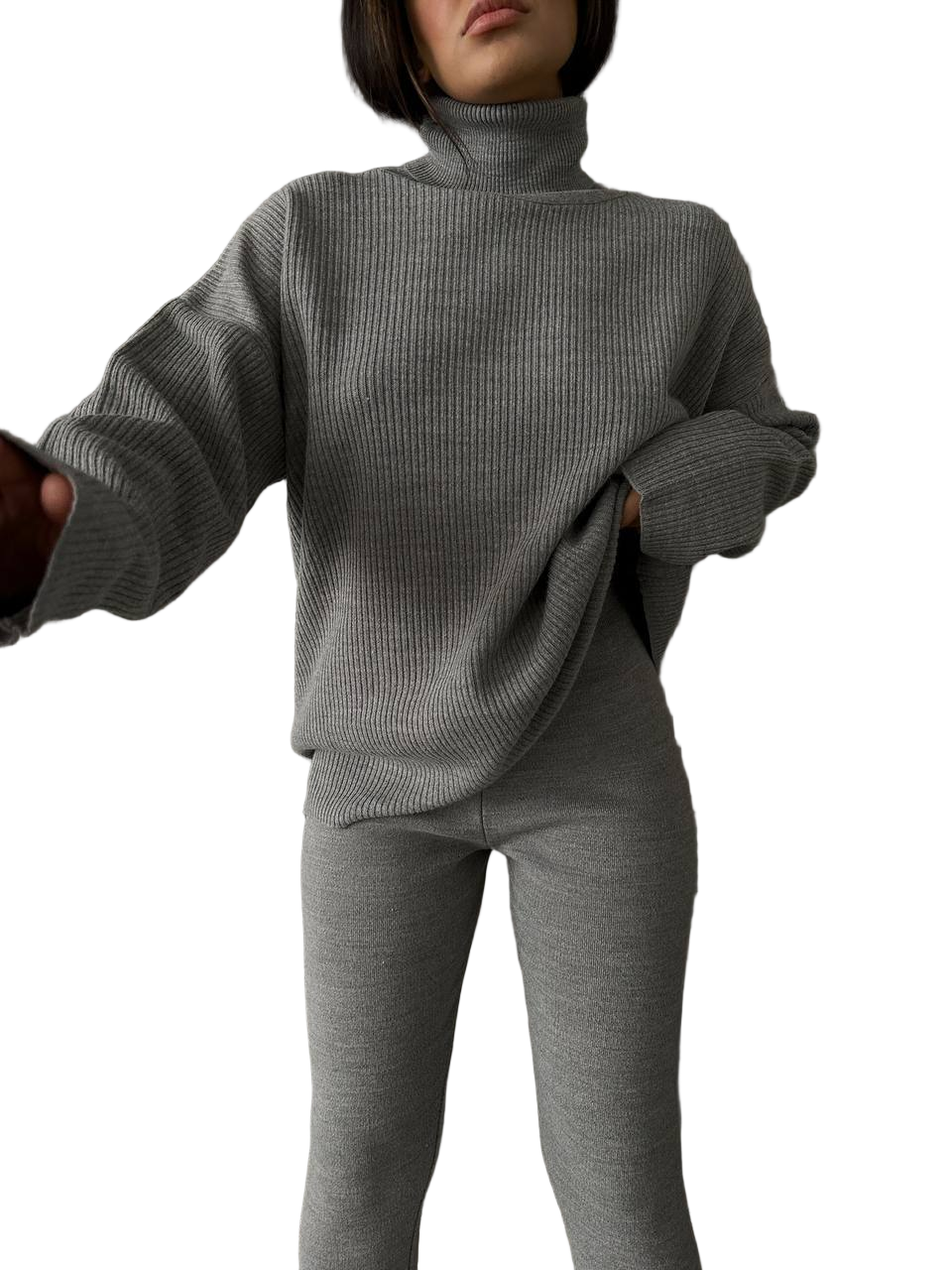Person wearing a gray ribbed sweater and pants on a white background