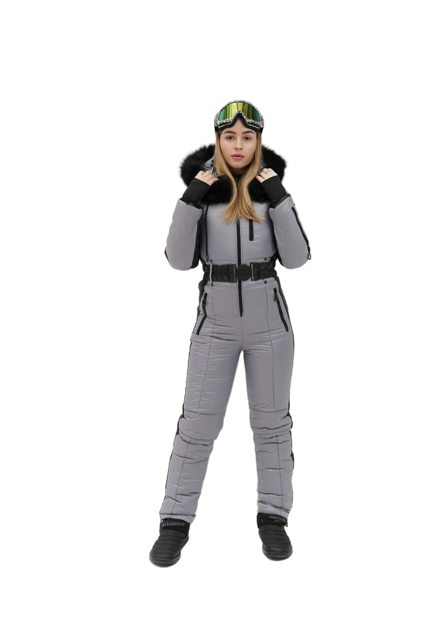 Person wearing a gray snowsuit with black boots and a helmet on a white background