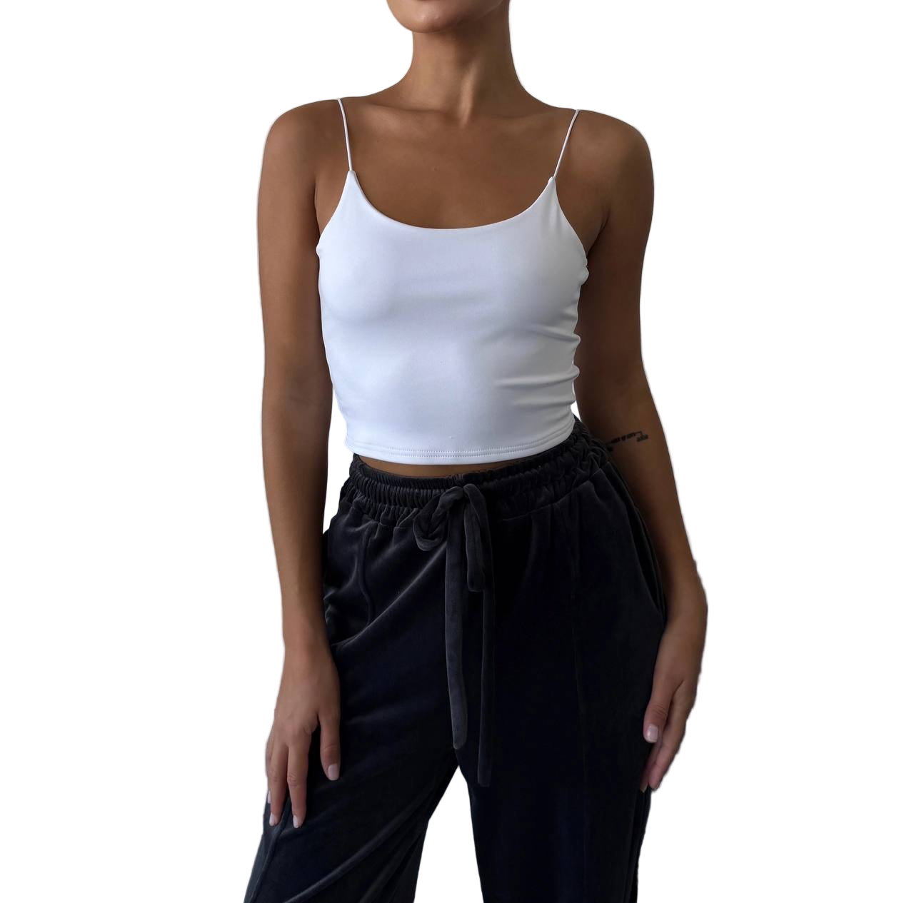 Person wearing a white tank top and black pants on a white background