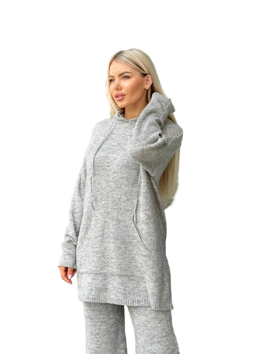 Woman wearing a gray hoodie and pants on a white background