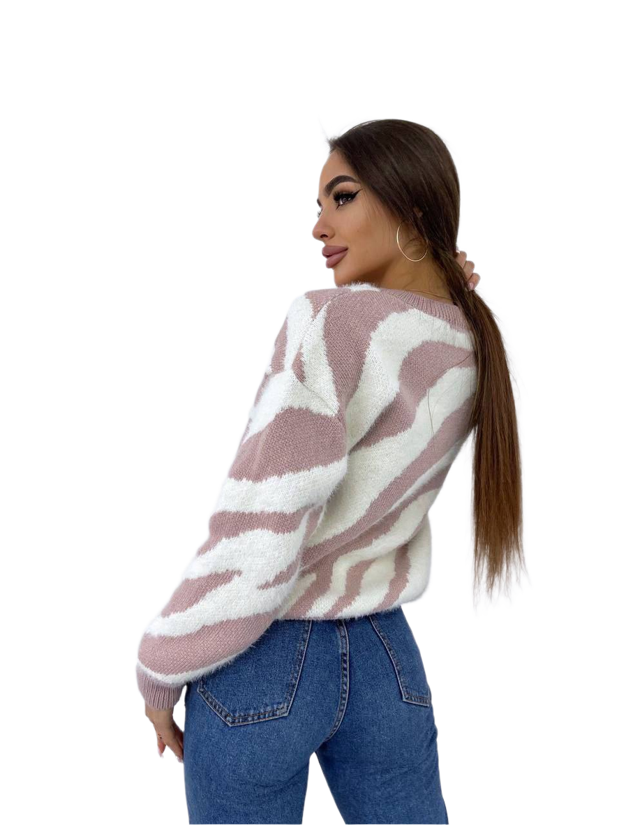 Woman wearing a patterned sweater and jeans on a white background