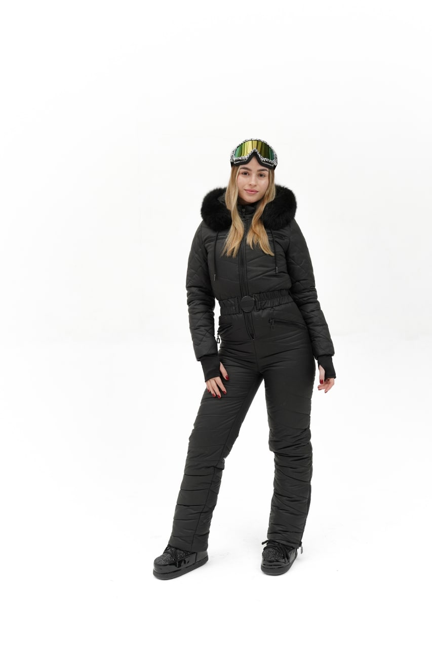 Person wearing a black winter suit with goggles on a white background