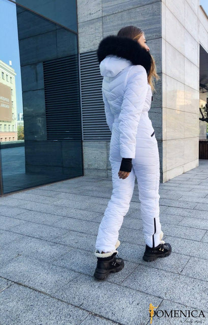 Person wearing a white puffer suit with a fur-lined hood in an urban setting.