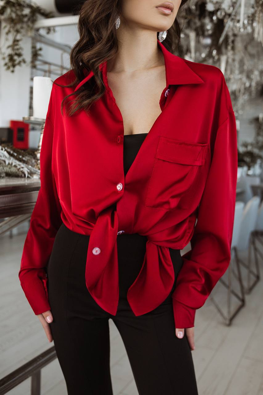 Person wearing a red jacket over a black top in an indoor setting