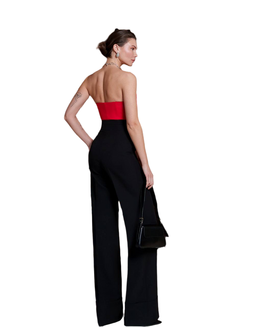 Woman wearing a black jumpsuit with a red top on a white background