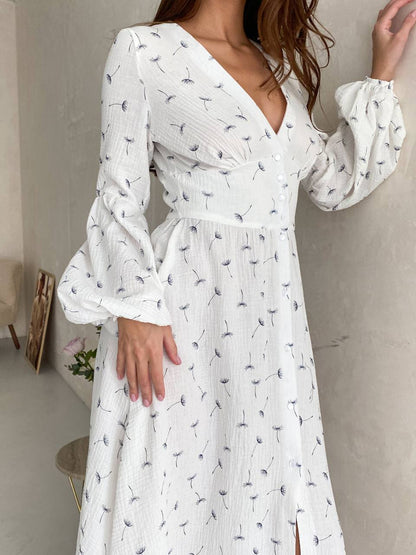 White dress with black floral pattern worn by a person indoors.