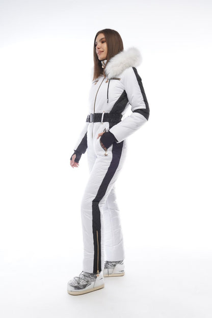 Woman wearing a white and black ski suit with fur trim on a white background