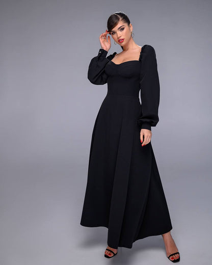 Woman wearing a black dress against a gray background