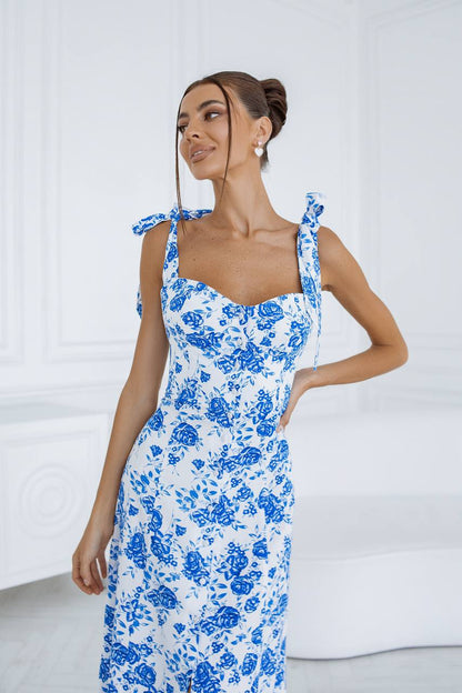 Woman wearing a blue floral dress against a white background