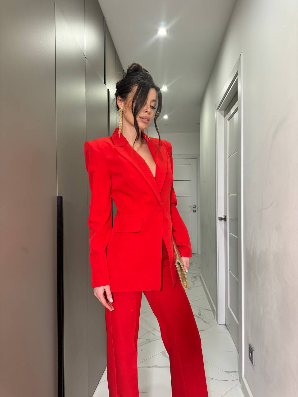 Person wearing a red suit standing in a hallway.