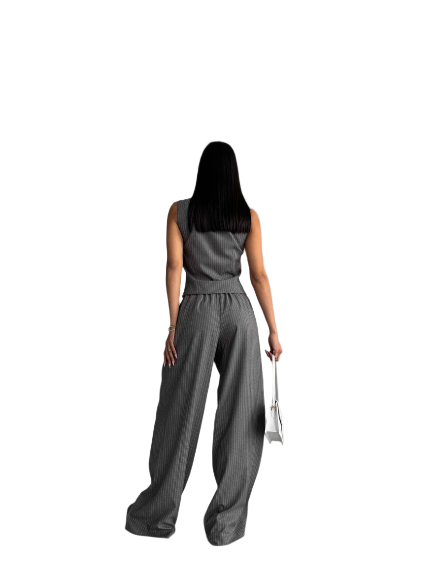 Woman wearing a gray sleeveless top and wide-leg pants on a white background