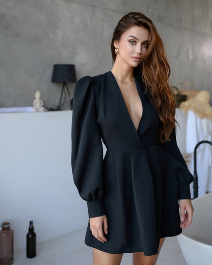 Woman wearing a black dress with puffed sleeves in an indoor setting.