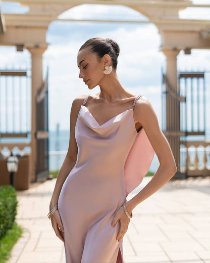 Woman in a pink dress standing outdoors with a blurred background