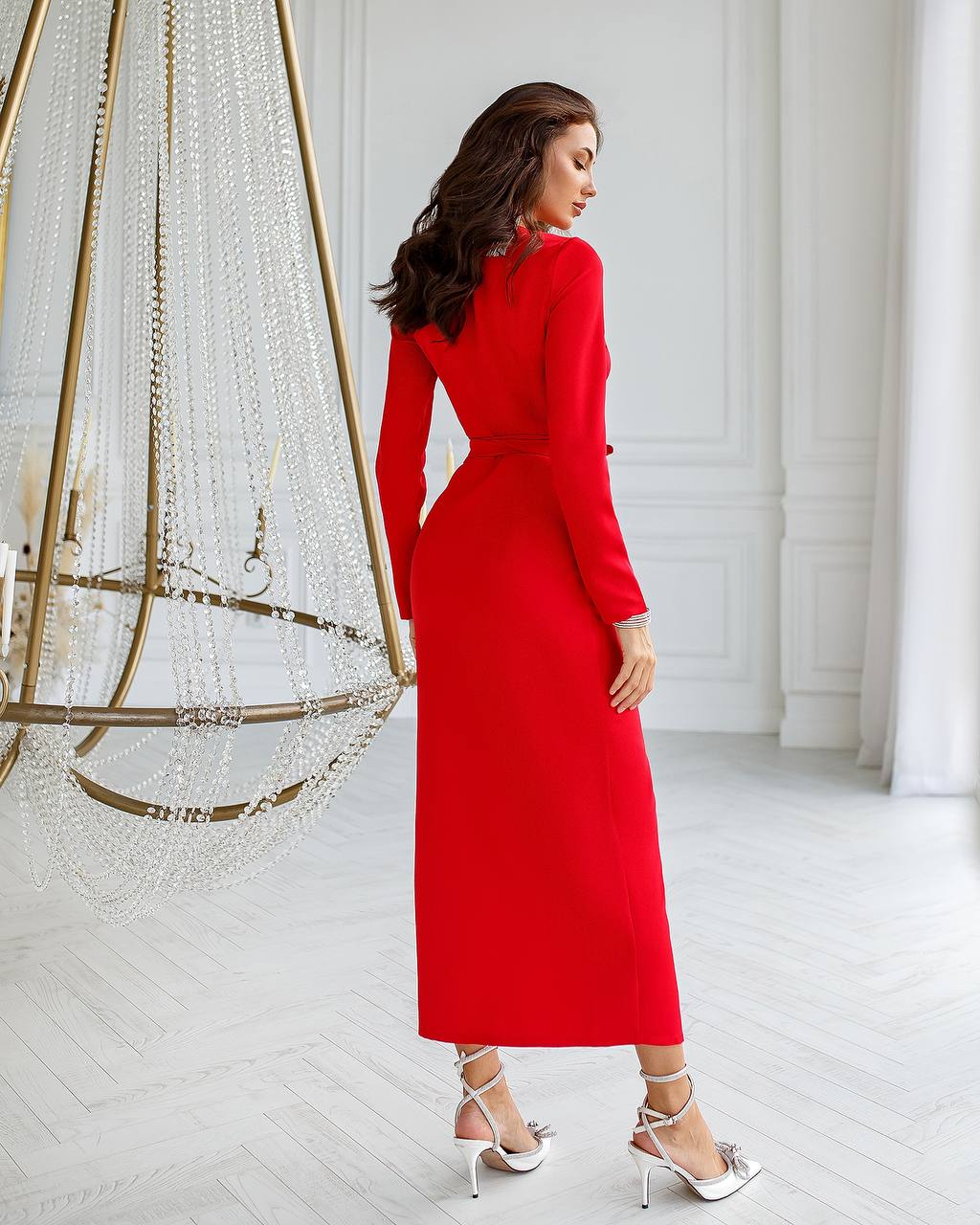 Woman wearing a red dress in a minimalistic room with decorative elements.
