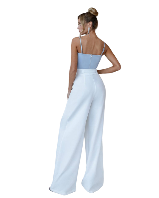 Woman wearing a light blue top and white pants on a white background