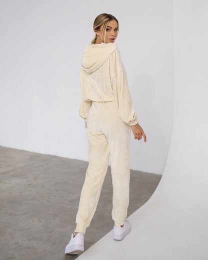 Woman wearing a beige tracksuit against a white background