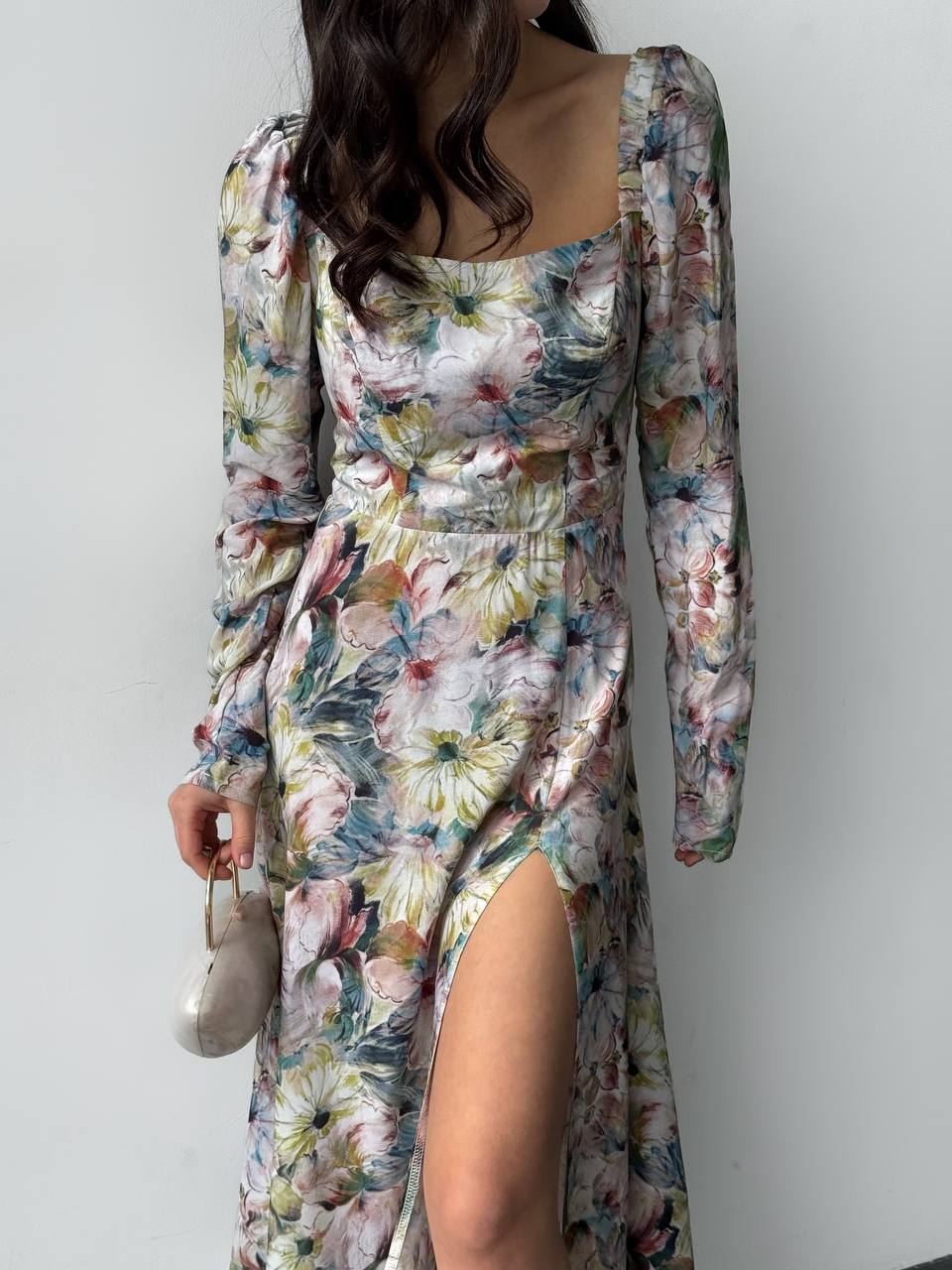 Floral dress with long sleeves and a slit on a plain background