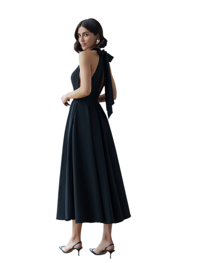 Woman wearing a black dress with a bow detail on a white background