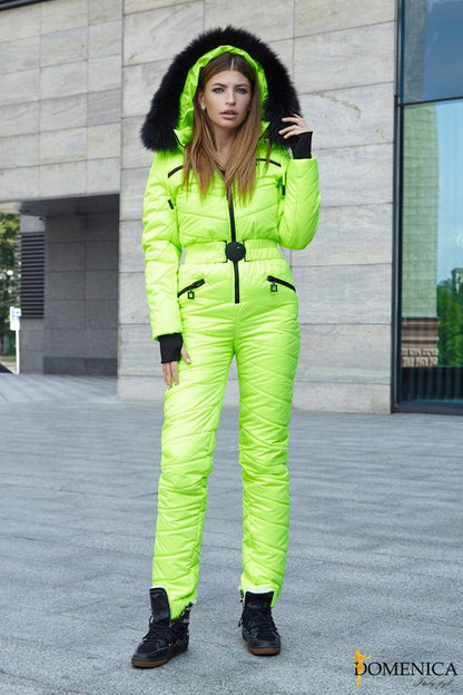 Woman wearing a bright green snowsuit with black fur hood in an urban setting.