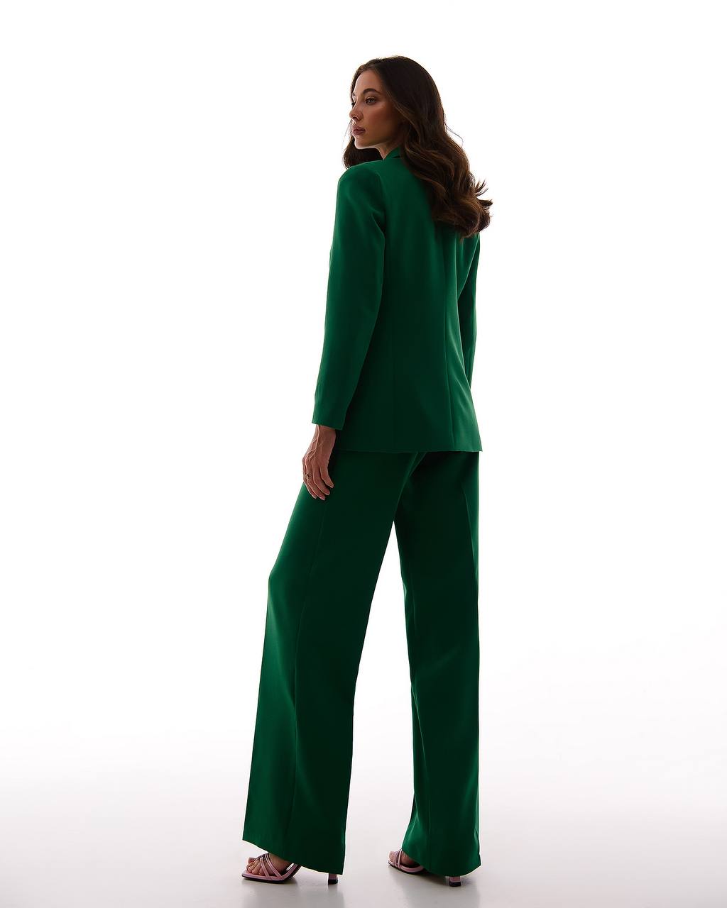Woman wearing a green suit on a white background