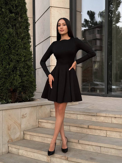 Woman in a black dress standing on steps outside a building