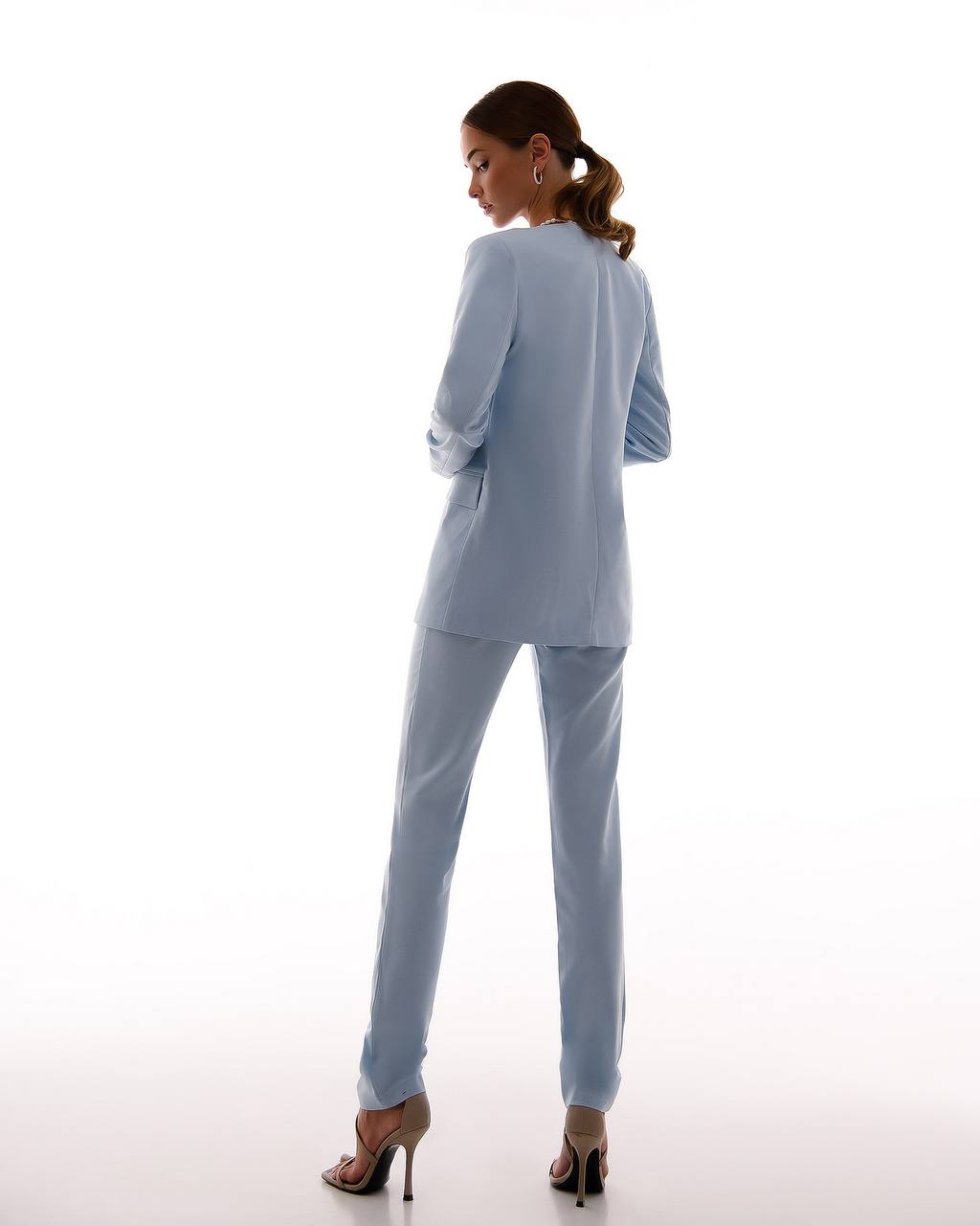 Woman wearing a light blue suit on a white background