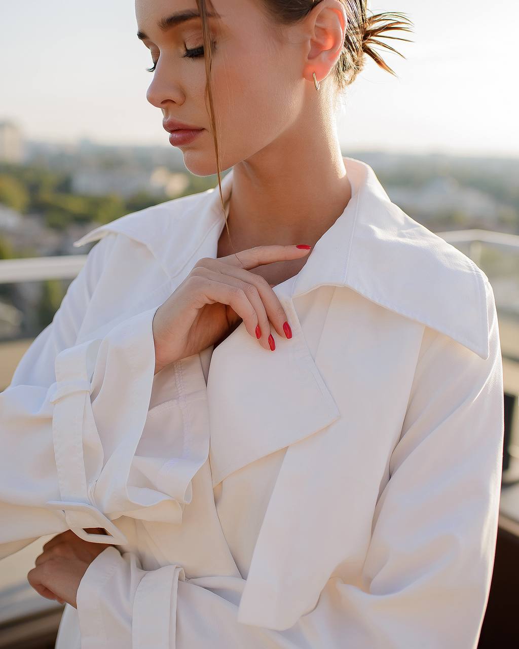 Woman wearing a white blouse with a blurred outdoor background