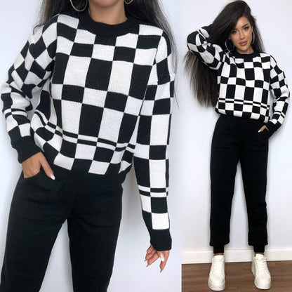 Two people wearing black and white checkered sweaters with a plain background