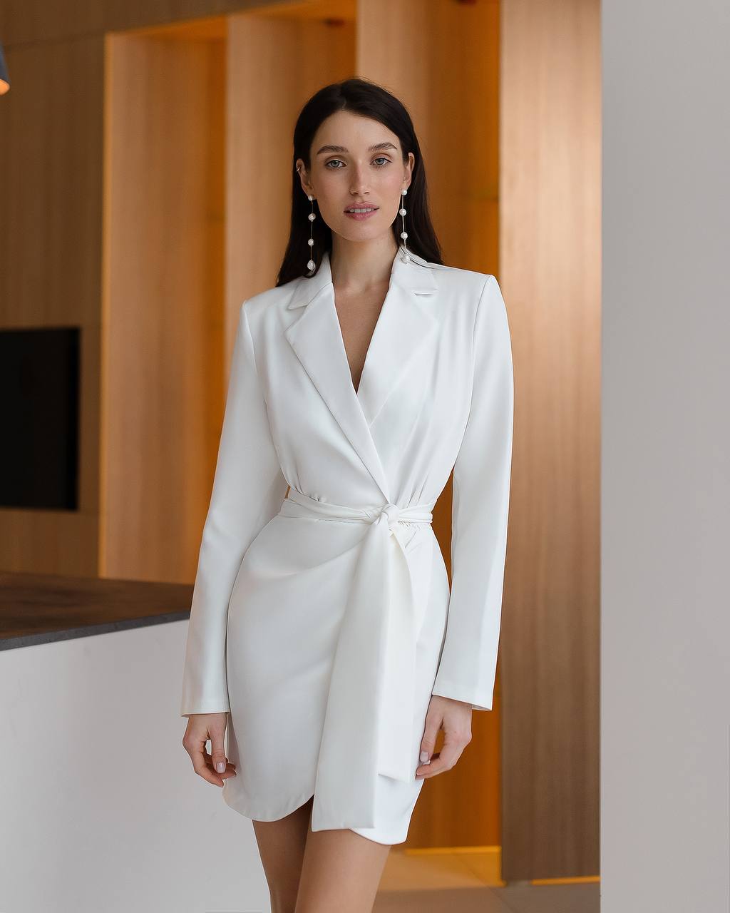 Woman wearing a white blazer dress in an indoor setting