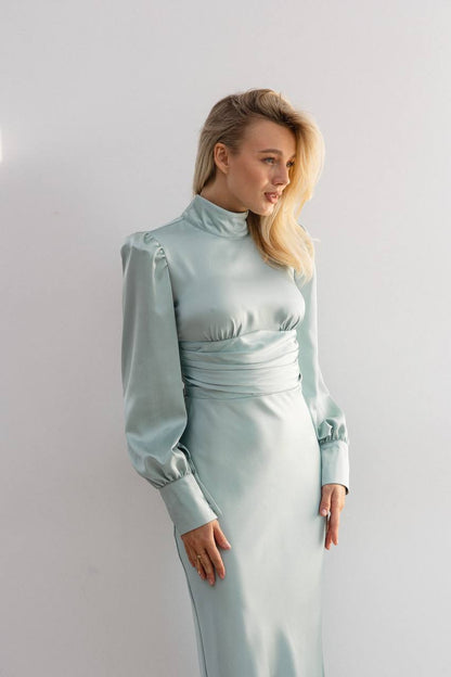 Woman wearing a light blue dress against a plain background