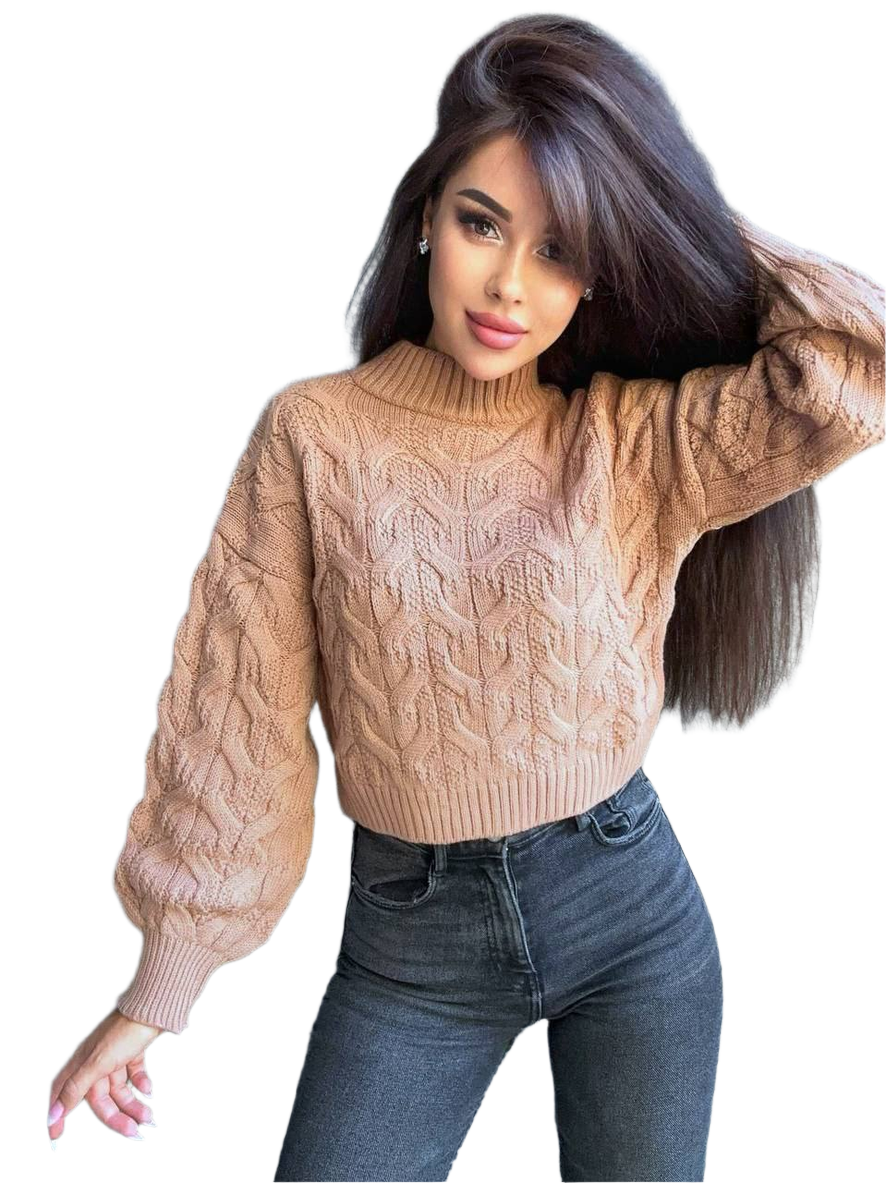 Woman wearing a beige cable knit sweater and blue jeans on a white background