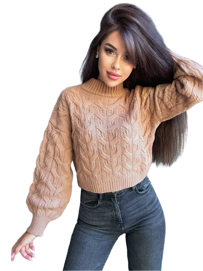 Woman wearing a beige cable knit sweater and blue jeans on a white background