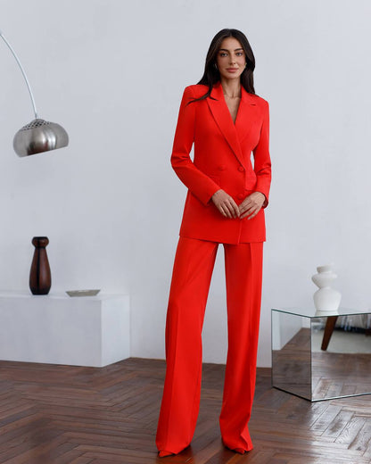 Woman wearing a red suit standing in a modern interior setting