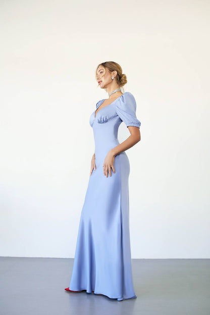 Woman wearing a light blue evening gown against a white background