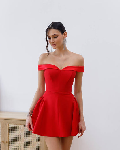 Woman wearing a red off-shoulder dress against a white background