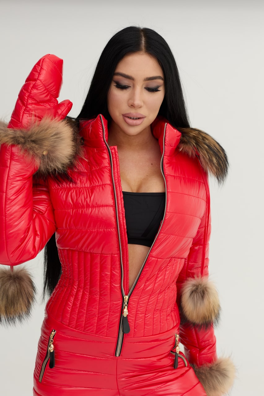 Woman wearing a red puffer jacket with fur trim on a white background