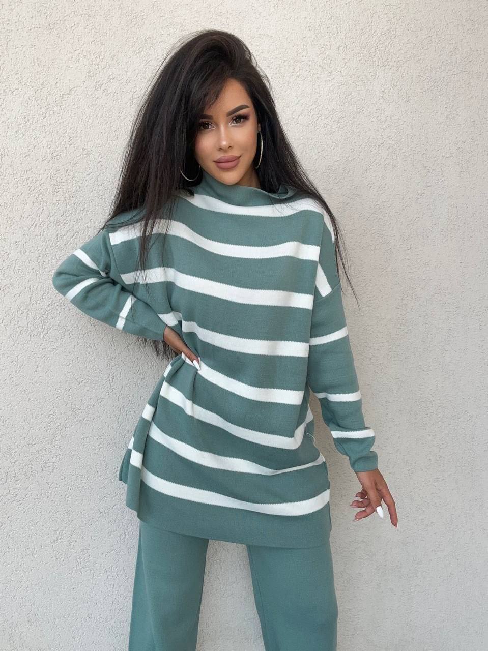 Woman wearing a green and white striped outfit against a light gray background