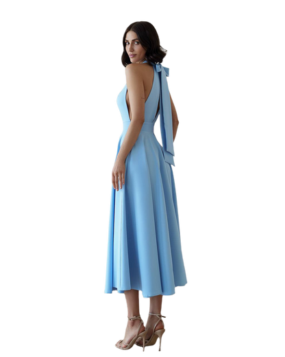 Woman wearing a light blue dress with a plunging neckline and shoulder straps on a white background